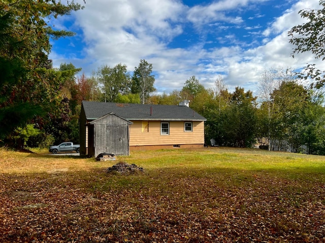 view of side of property with a lawn and a storage unit