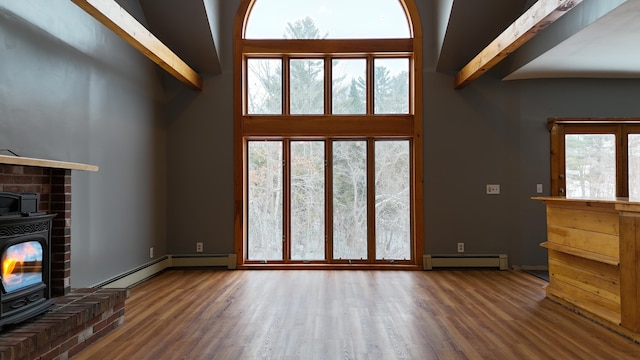 unfurnished living room featuring dark hardwood / wood-style flooring, a wood stove, beamed ceiling, and baseboard heating