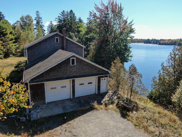 view of side of home featuring a garage and a water view