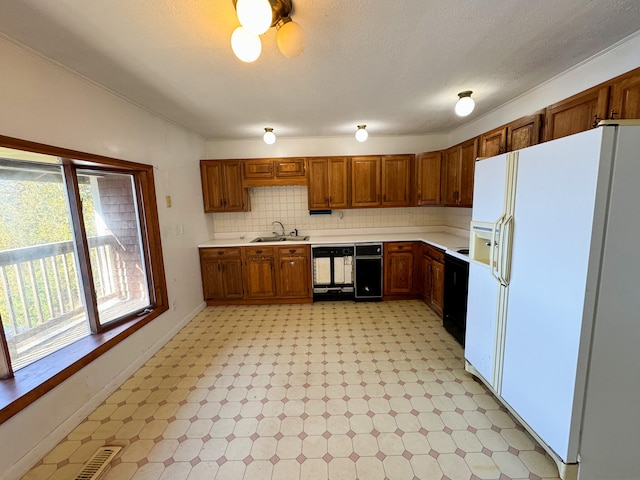 kitchen with sink, a textured ceiling, white fridge with ice dispenser, black dishwasher, and decorative backsplash