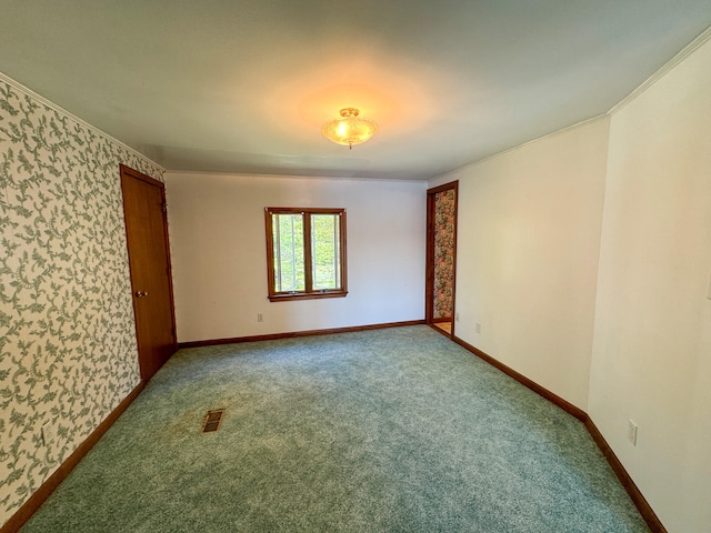 empty room with ornamental molding and carpet