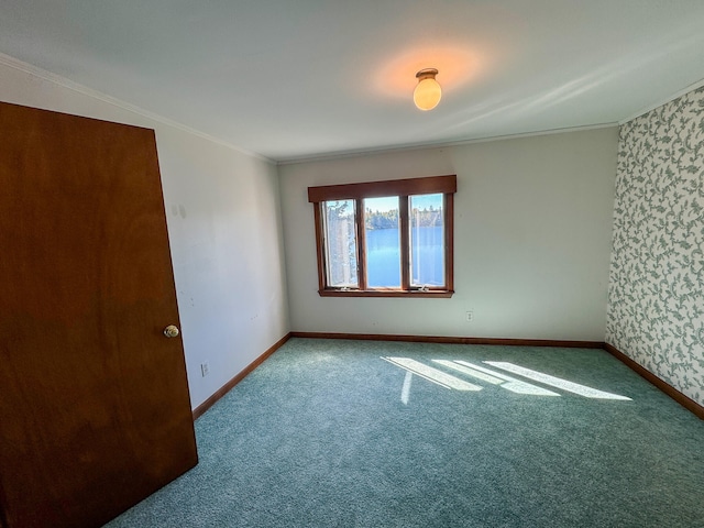 carpeted spare room featuring crown molding