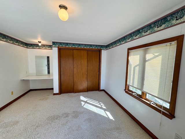 unfurnished bedroom with light carpet and a closet