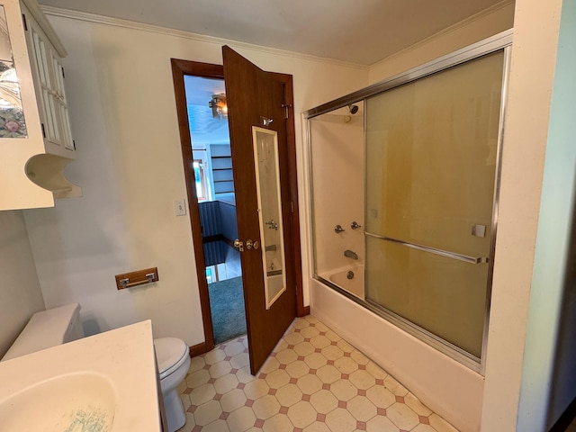 full bathroom featuring vanity, ornamental molding, combined bath / shower with glass door, and toilet