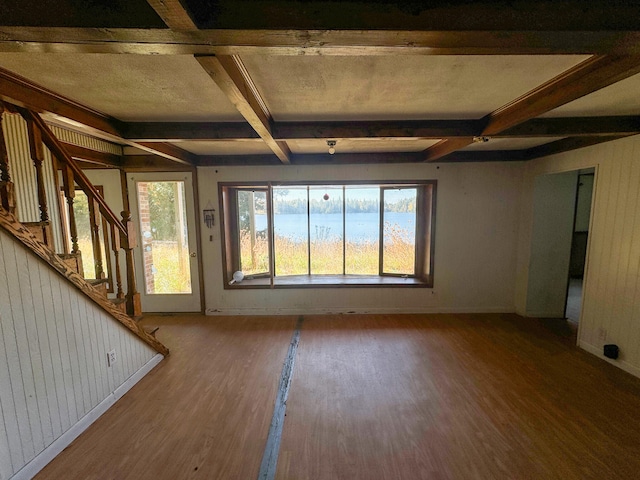 unfurnished living room with wood-type flooring, beamed ceiling, wooden walls, and coffered ceiling