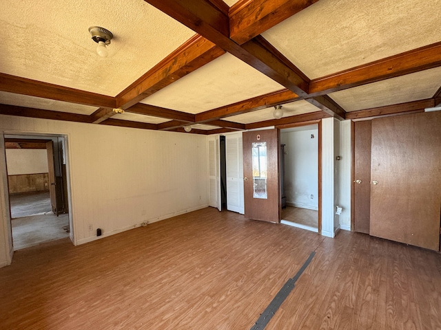 interior space featuring wood-type flooring, beam ceiling, a textured ceiling, and coffered ceiling