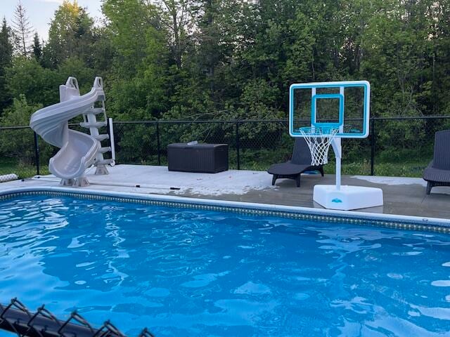 view of swimming pool featuring a patio and a water slide