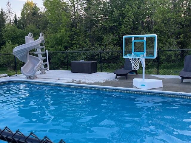 473 Wolfboro Rd, Stetson, ME 04488 - view of pool featuring fence, a patio area, a fenced in pool, a water slide, and a wooded view