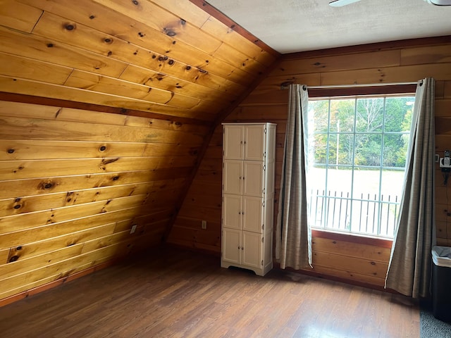 bonus room featuring wood-type flooring, vaulted ceiling, and wood walls