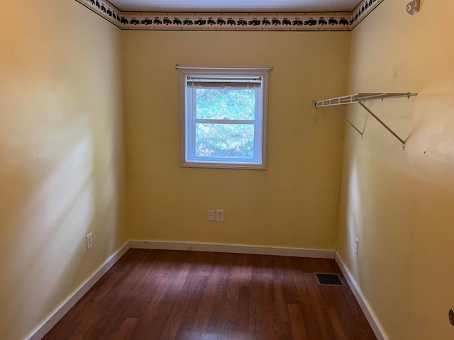 unfurnished room with dark hardwood / wood-style flooring