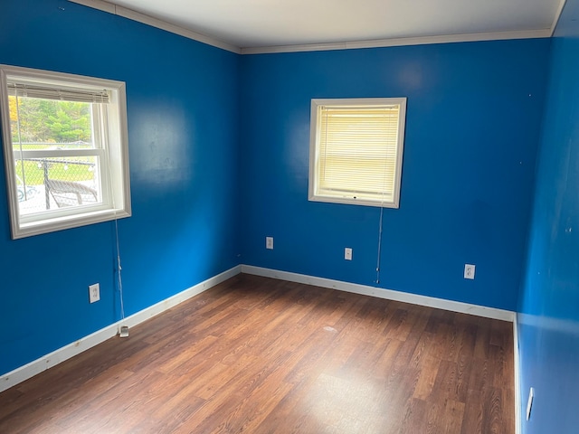 spare room with hardwood / wood-style flooring and crown molding