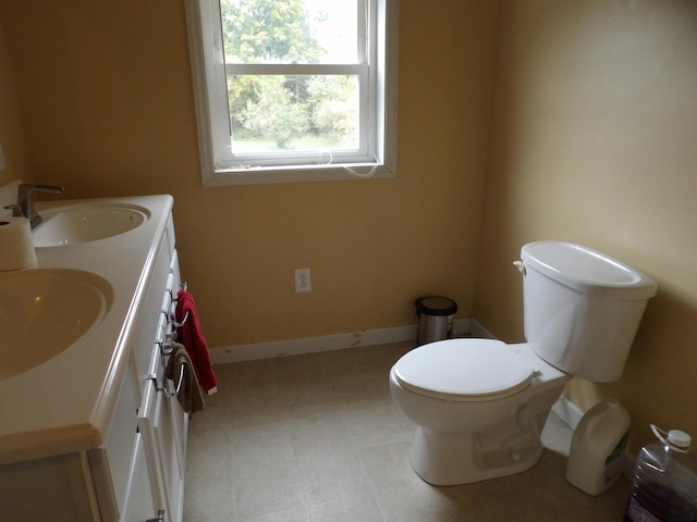 473 Wolfboro Rd, Stetson, ME 04488 - bathroom with double vanity, toilet, baseboards, and a sink
