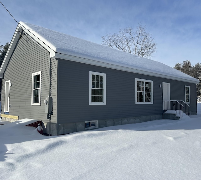 view of snow covered back of property