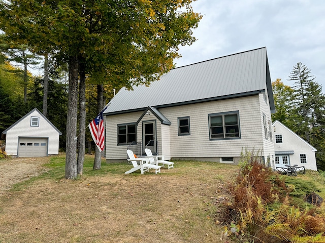 view of front of home with an outdoor structure, a garage, and a front yard