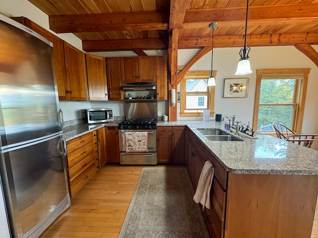 kitchen with light hardwood / wood-style floors, sink, beam ceiling, appliances with stainless steel finishes, and decorative light fixtures