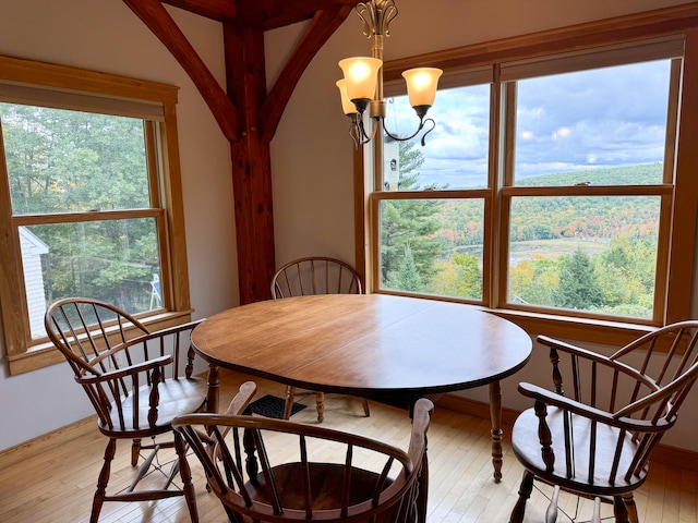 dining room featuring light wood-type flooring, a notable chandelier, and a wealth of natural light