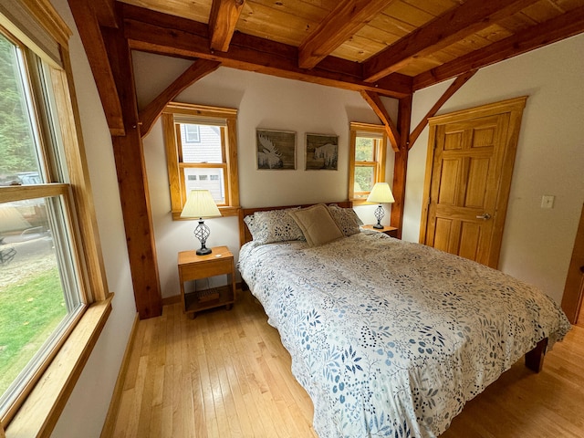 bedroom featuring beamed ceiling, light wood-type flooring, and wood ceiling