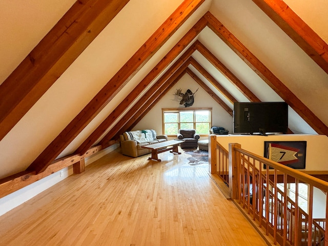 bonus room featuring lofted ceiling with beams and light hardwood / wood-style flooring