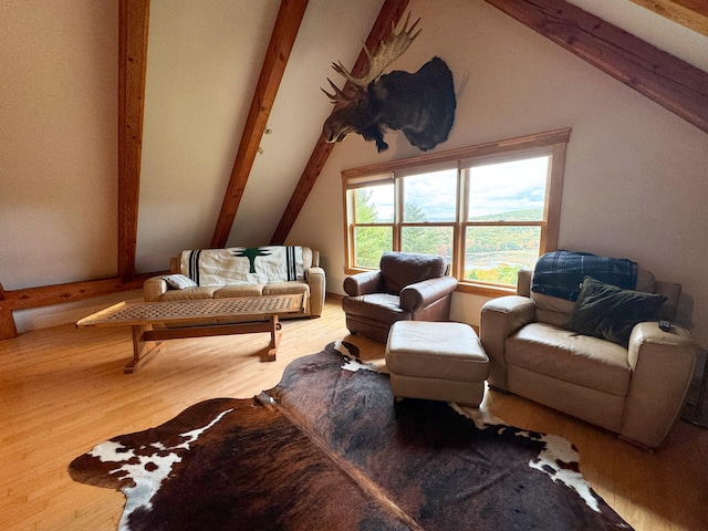 living area with hardwood / wood-style flooring and lofted ceiling with beams