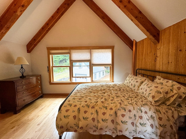 bedroom featuring wooden walls, beam ceiling, light hardwood / wood-style floors, and high vaulted ceiling