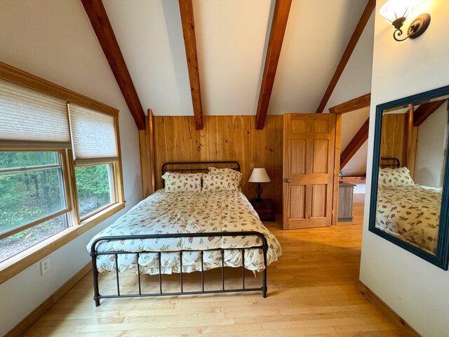 bedroom featuring light hardwood / wood-style floors, beamed ceiling, and high vaulted ceiling