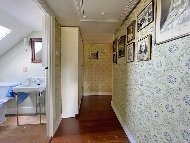 hall with ornamental molding, vaulted ceiling, and dark hardwood / wood-style flooring