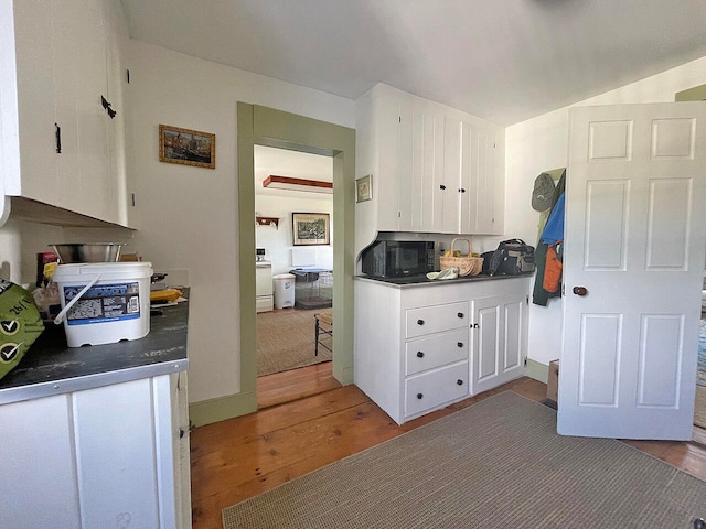 kitchen featuring white cabinetry, wood-type flooring, and white range with electric cooktop