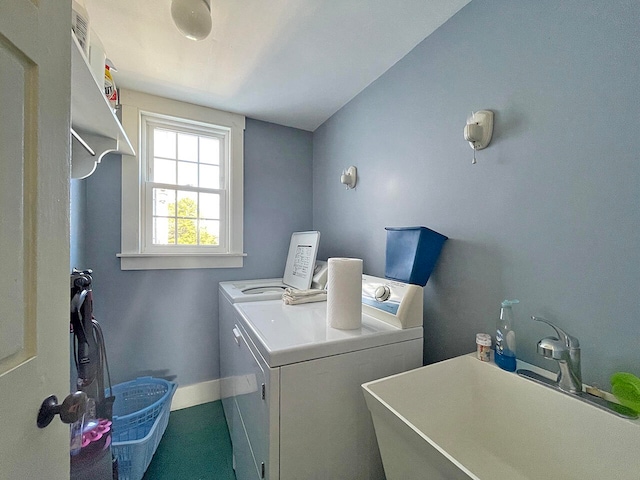 clothes washing area with washing machine and dryer and sink