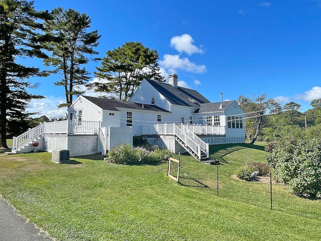 view of side of home with central AC unit and a lawn