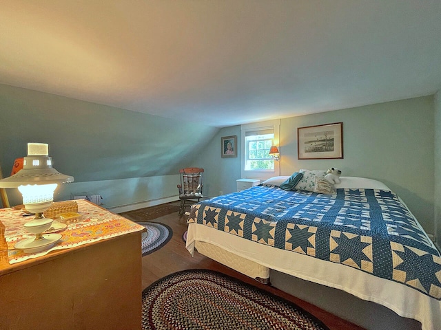 bedroom featuring baseboard heating, wood-type flooring, and vaulted ceiling