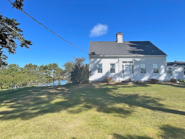 rear view of house featuring a lawn