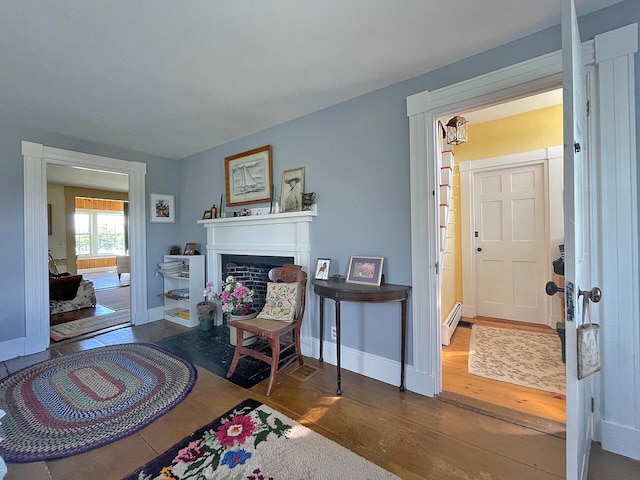 living area featuring dark hardwood / wood-style flooring and a baseboard heating unit