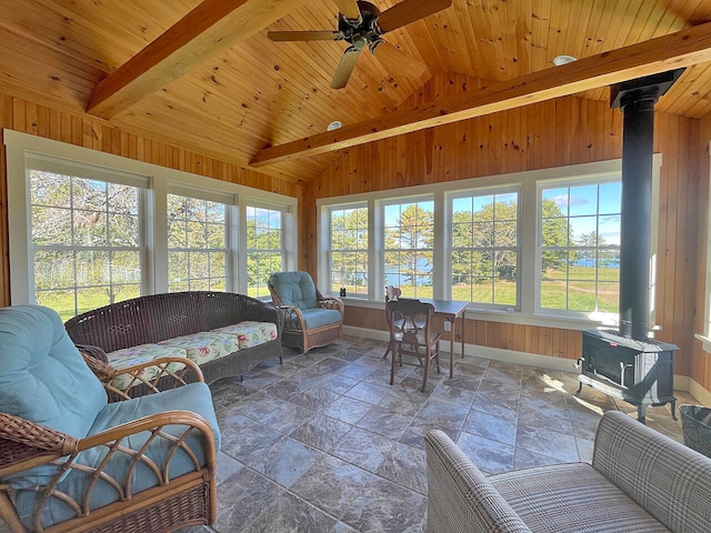 sunroom featuring wood ceiling, a wood stove, vaulted ceiling with beams, and ceiling fan