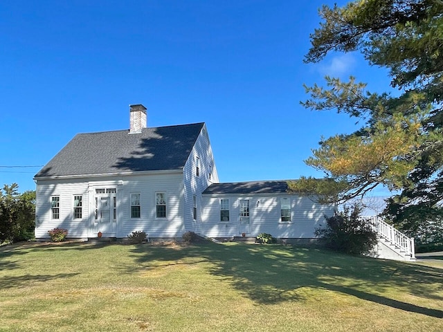 rear view of house featuring a yard