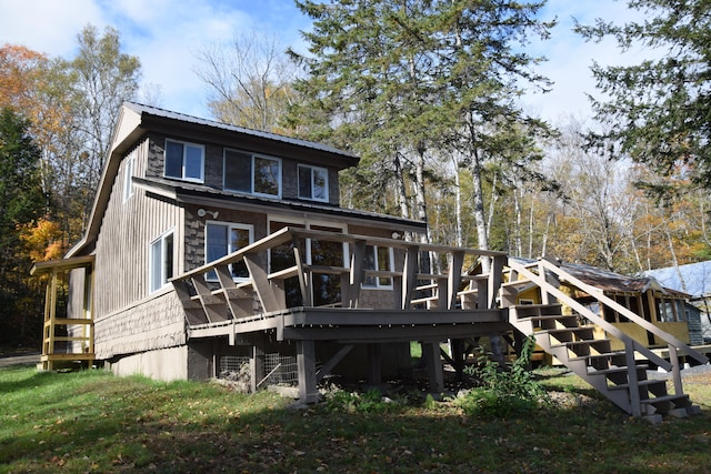 back of house with a deck and a lawn