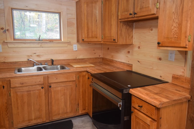 kitchen with black electric range, wood walls, sink, and wooden counters