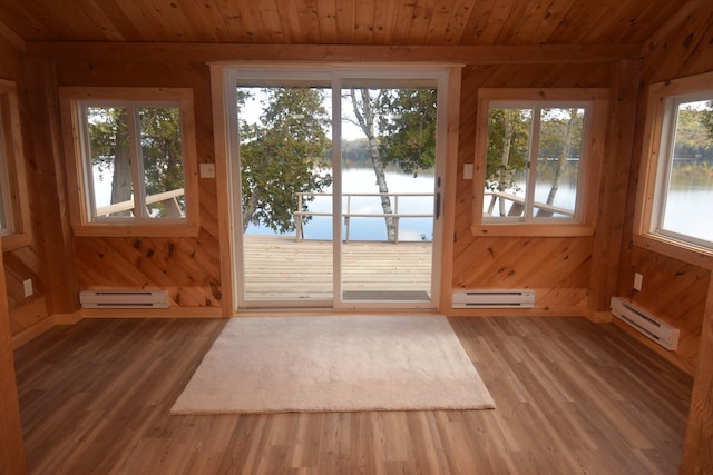 doorway to outside featuring hardwood / wood-style floors and a baseboard heating unit