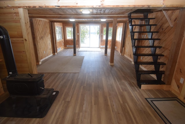 basement with wood-type flooring, a baseboard radiator, wooden walls, and wooden ceiling