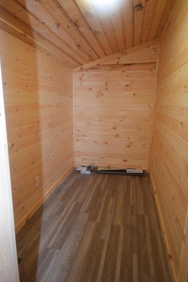 unfurnished room with hardwood / wood-style floors, wooden walls, vaulted ceiling, and wooden ceiling