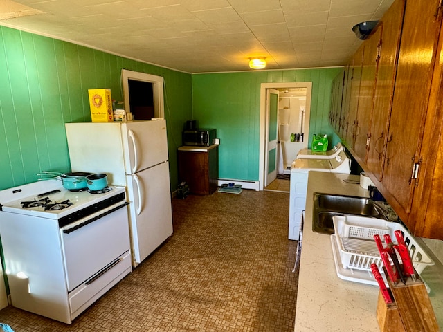 kitchen featuring washer / clothes dryer, wooden walls, a baseboard heating unit, and white appliances