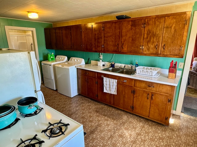 kitchen with sink, independent washer and dryer, and white appliances