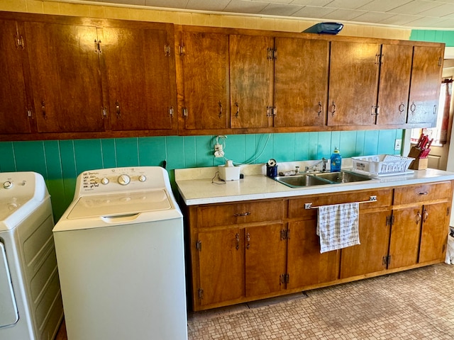 laundry area featuring sink, washer and dryer, and cabinets