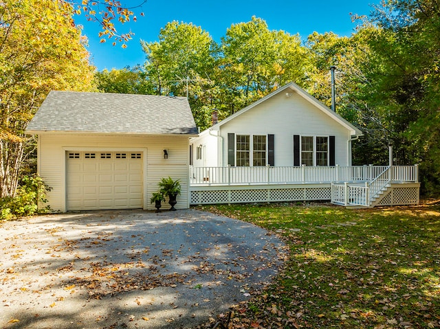 view of front facade with a front lawn, a deck, and a garage