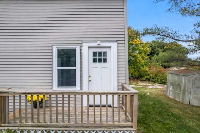 doorway to property with a lawn and a deck