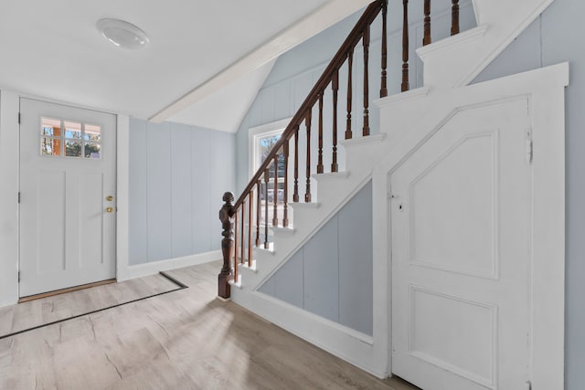 foyer featuring light wood-type flooring, vaulted ceiling, and a wealth of natural light