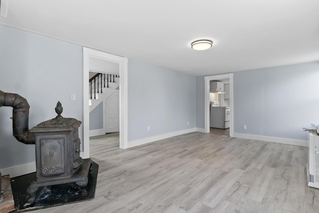 5 Harbor Rd, Friendship, ME 04547 - unfurnished living room with light wood finished floors, stairs, a wood stove, and baseboards