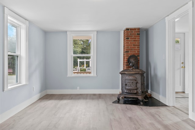 unfurnished living room featuring light hardwood / wood-style flooring and a wood stove