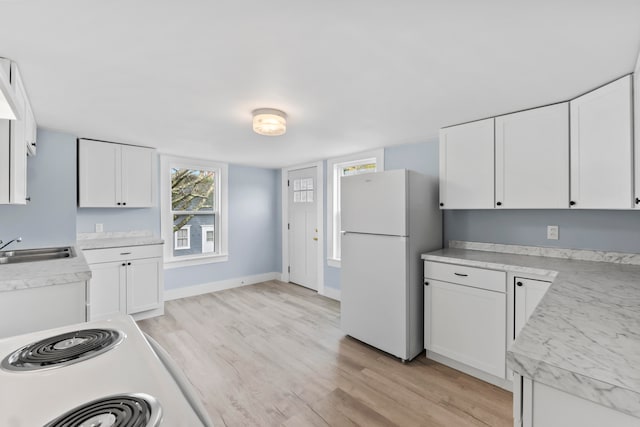 kitchen featuring white cabinetry and white fridge