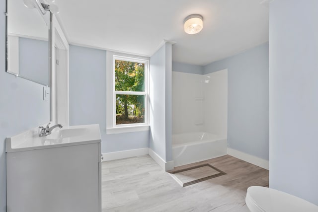 full bathroom featuring hardwood / wood-style floors, tub / shower combination, vanity, and toilet