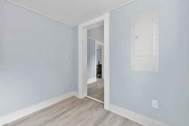 empty room featuring electric panel and light hardwood / wood-style floors